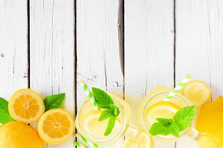 Sweet summer lemonade, top view border on a white wood backgroundの写真素材