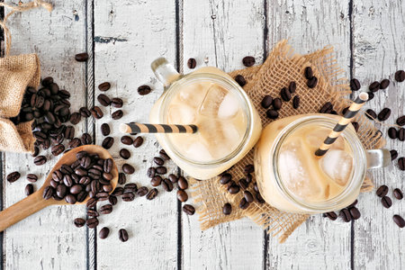 Summer iced coffee table scene over a rustic white wood background