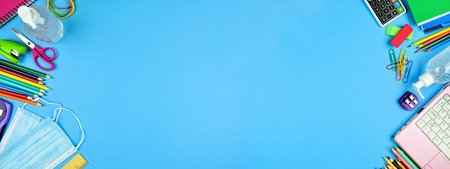 School supplies and COVID 19 prevention items. Double border on a blue paper banner background. Back...