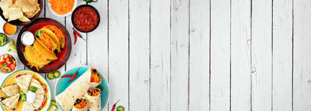 Mexican food corner border, top view over a white wood banner background. Tacos, quesadilla, burritos and nachos. Copy space.の写真素材