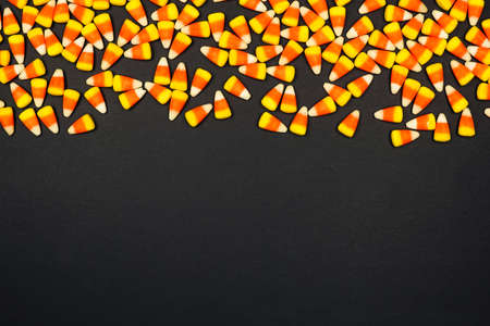 Halloween candy corn top border. Top view on a black background with copy space.の写真素材