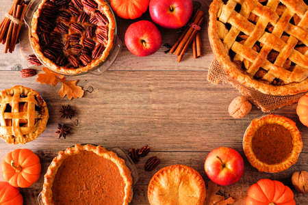 Homemade autumn pies. Apple, pumpkin and pecan. Top view frame over a rustic wood background with copy space.の写真素材
