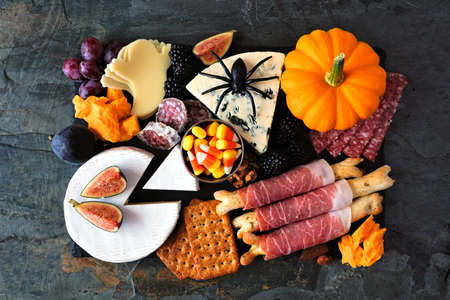 Halloween theme charcuterie board. Top down view against a dark background. Assortment of cheese and meat appetizers.の写真素材