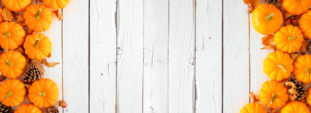 Autumn decor on a white shelf against a white wall background. Banner with copy space. Candle,...