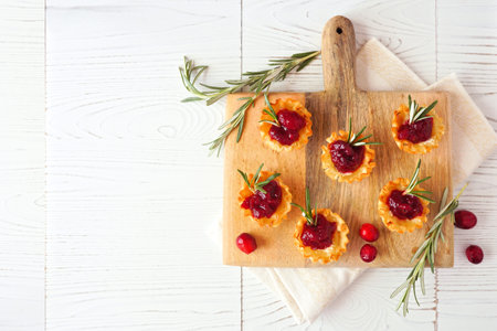 Platter of holiday phyllo pastry appetizers with cranberries and baked brie. Top view table scene...