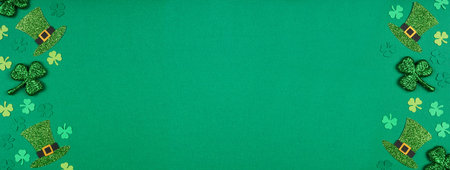 St Patricks Day shamrock and leprechaun hat double border. Top view over a green paper banner...