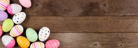 Colorful Easter Egg corner border. Top down view against a rustic wood banner background. Copy...