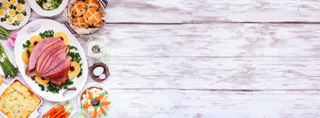 Traditional Easter ham dinner. Top down view side border on a white wood banner background with copy...