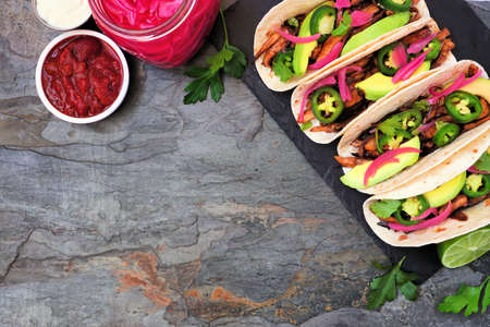 Vegan mushroom tacos. Overhead view on a dark slate background with copy space. Healthy eating, plant-based meat substitute concept.の写真素材