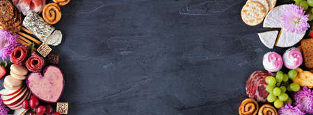 Mother's Day charcuterie double border against a dark slate banner background. Assorted cheese, meat, fruit and sweet appetizers. Copy space.の写真素材