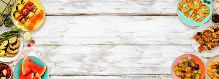 Healthy plant based summer bbq double border. Overhead view on a white wood banner background. Fruit, grilled vegetables, skewers, cauliflower steak and lemonade. Copy space. Meat substitute concept.の写真素材