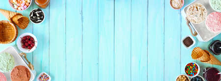 Summer ice cream buffet with a mixture of flavors and sweet toppings. Top view table scene on a blue wood background.の写真素材