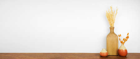 Fall decor on a wood shelf against a white wall background. Banner with copy space. Vases and seasonal branches.の写真素材