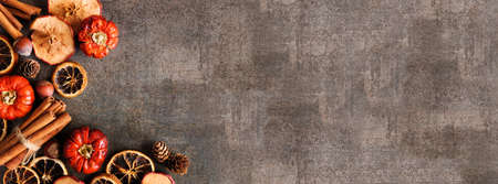 Fall theme baking spices and ingredients. Corner border on a dark stone banner background with copy space. Above view.の写真素材