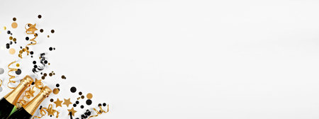 New Years Eve corner border of gold and black confetti, streamers and champagne. Above view over a...
