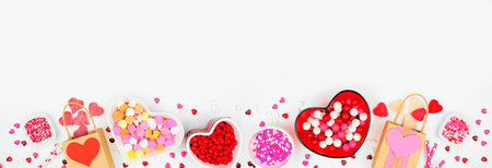 Valentines Day sweets bottom border with an assortment of sweets. Top view on a white banner...