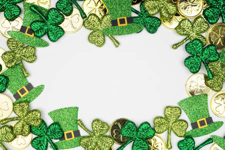 St Patricks Day frame against a white background. Above view with gold coins, shamrocks and leprechaun hats. Copy space.の写真素材