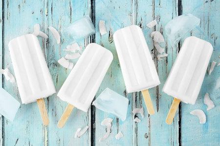 Coconut ice pops scattered over a blue wood background