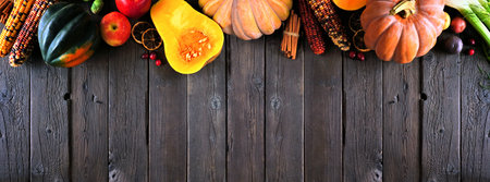 Autumn food top border with pumpkins, apples, squash and a selection of vegetables. Above view on a...
