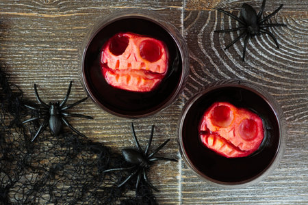 Spooky Halloween apple head punch in two glasses. Above view table scene on a dark wood background.の写真素材