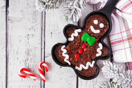 Christmas gingerbread man brownie. Above view table scene against a white wood background. Holiday baking concept.の写真素材