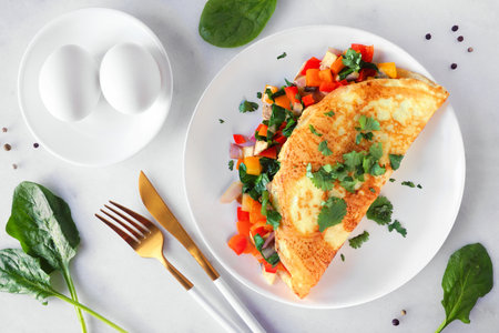 Healthy vegetable loaded omelette. Above view table scene over a white marble background.の写真素材