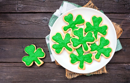 St Patricks Day shamrock cookies. Above view table scene on a dark wood background.の写真素材