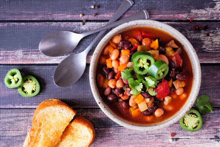 Homemade vegetarian chili. Above view table scene on a dark wood backgroundの写真素材