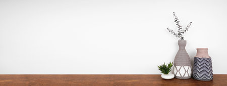 Home decor and plant on a shelf. Clay vases and succulent plant on a wood shelf against a white wall. Banner with copy space.の写真素材