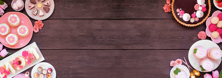 Mothers Day double border with an assortment of desserts and sweets. Top view on a dark wood banner background. Pink flowers theme. Copy space.の写真素材