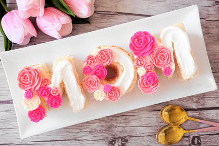 Mothers Day MOM cake with pink and white candy flowers. Above view table scene over a wood background.の写真素材