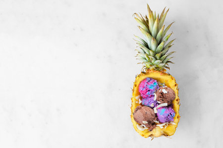 Summer ice cream in a pineapple. Top view on a bright marble background with copy space.の写真素材