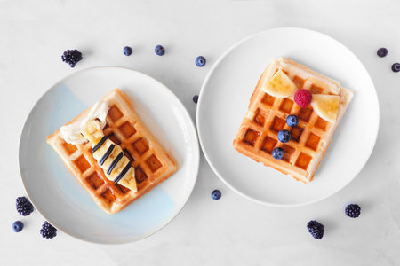 Child's Fathers Day shirt waffles with necktie and bowtie with buttons. Fathers Day breakfast concept. Above view on a white marble background.の写真素材