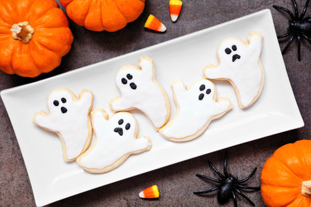Plate of Halloween ghost cookies. Top down view table scene on a dark background.の写真素材