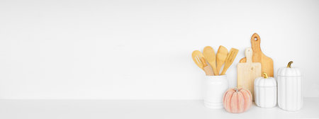 Autumn theme kitchenware, utensils and decor on a white shelf or counter. Banner against a white wall background with copy space. Fall kitchen, home cooking concept.の写真素材