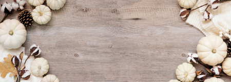 Cozy autumn double border with sweater, white pumpkins natural decor. Overhead view over a desaturated wood banner background.の写真素材