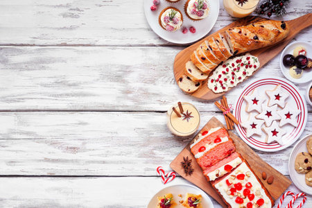 Christmas food side border. Top down view on a white wood background. Assorted appetizers and delicious sweets. Copy space. Holiday party food concept.の写真素材