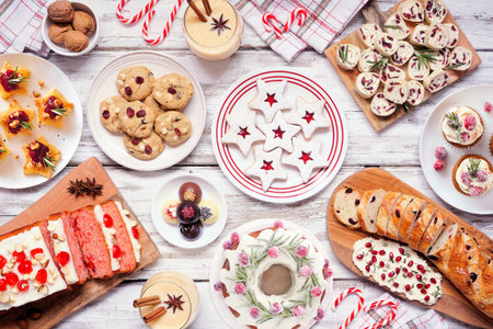Christmas food table scene. Above view on a white wood background. Collection of appetizers and delicious sweets. Copy space. Holiday party food concept.の写真素材