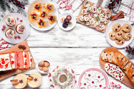 Christmas food frame. Above view on a white wood background. Group of appetizers and delicious sweets. Copy space. Holiday party food concept.の写真素材