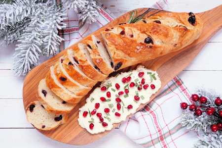 Cranberry baguette with pomegranate cream cheese spread. Top view table scene against a white wood background. Winter or Christmas theme appetizer.の写真素材