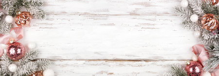 Christmas double border of snowy branches, frosty pink ribbon and rose gold ornaments. Above view on a white wood banner background. Copy space.の写真素材