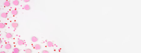 Valentines Day corner border of candy hearts and sprinkles. Overhead view on a white banner background. Copy space.の写真素材