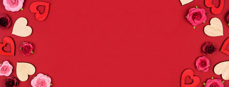 Valentines Day double border of wooden hearts and roses. Top view on a red banner background. Copy...