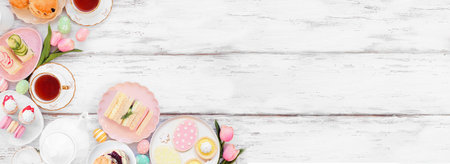 Easter or spring tea corner border against a white wood banner background. Assortment of finger sandwiches, scones and sweet desserts. Overhead view. Copy space.の写真素材