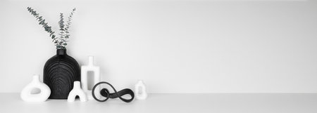 Modern black and white home decor on a white shelf against a white wall. Banner with copy space.の写真素材