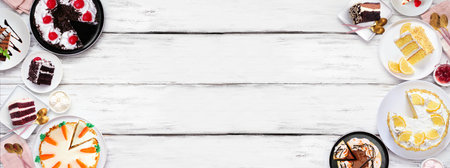 Dessert double border with a variety of cakes. Above view over a white wood banner background. Copy space. Black forest, lemon, carrot, red velvet, chocolate and cheesecakes.の写真素材