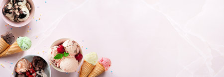 Summer ice cream corner border. Bowls and cones of colorful assorted flavors. Top view on a soft pink stone banner background. Copy space.の写真素材