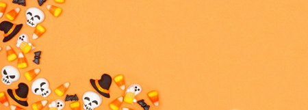 Halloween candy corner border. Top view against an orange banner background with copy space.