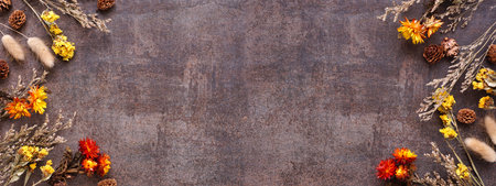 Fall double border of dried flowers and grasses. Top down view on a rustic dark banner background....