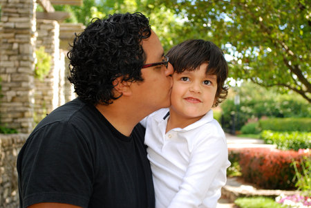 Hispanic father kissing his sonの写真素材